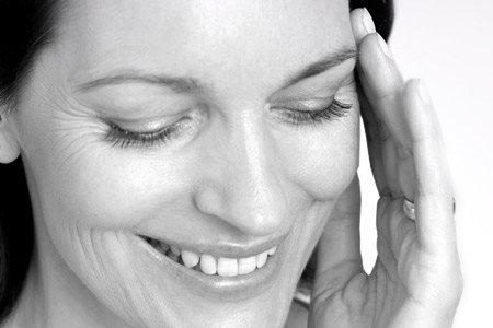 Woman touching her face with her left hand.