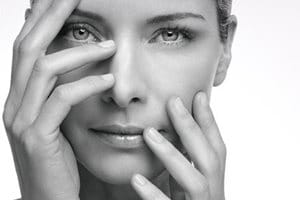 Woman holding up her hands in front of her face.