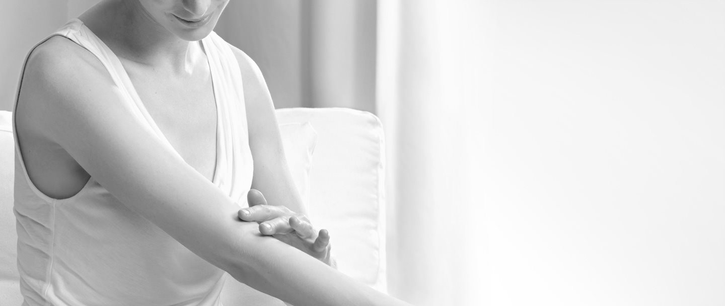 Woman touching the crook of her arm.